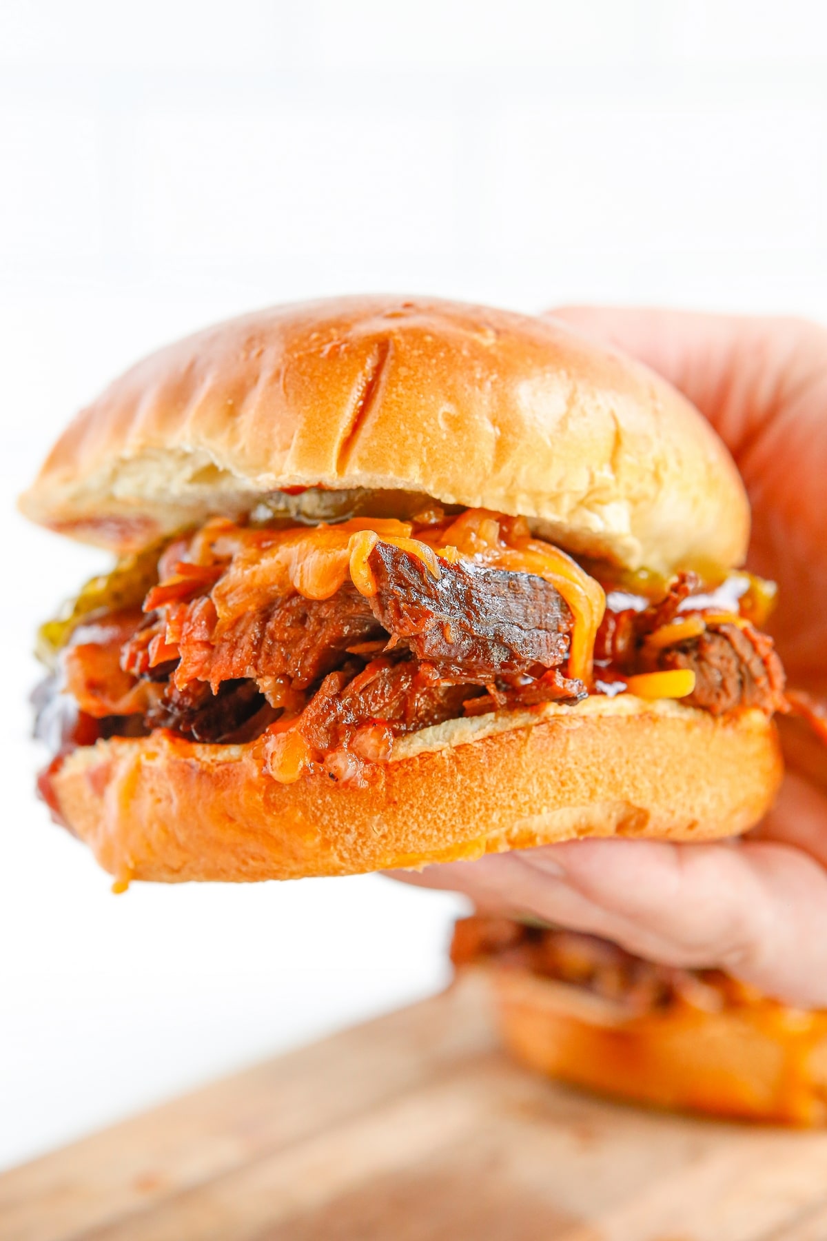 a slow cooker bbq beef sandwich being handheld