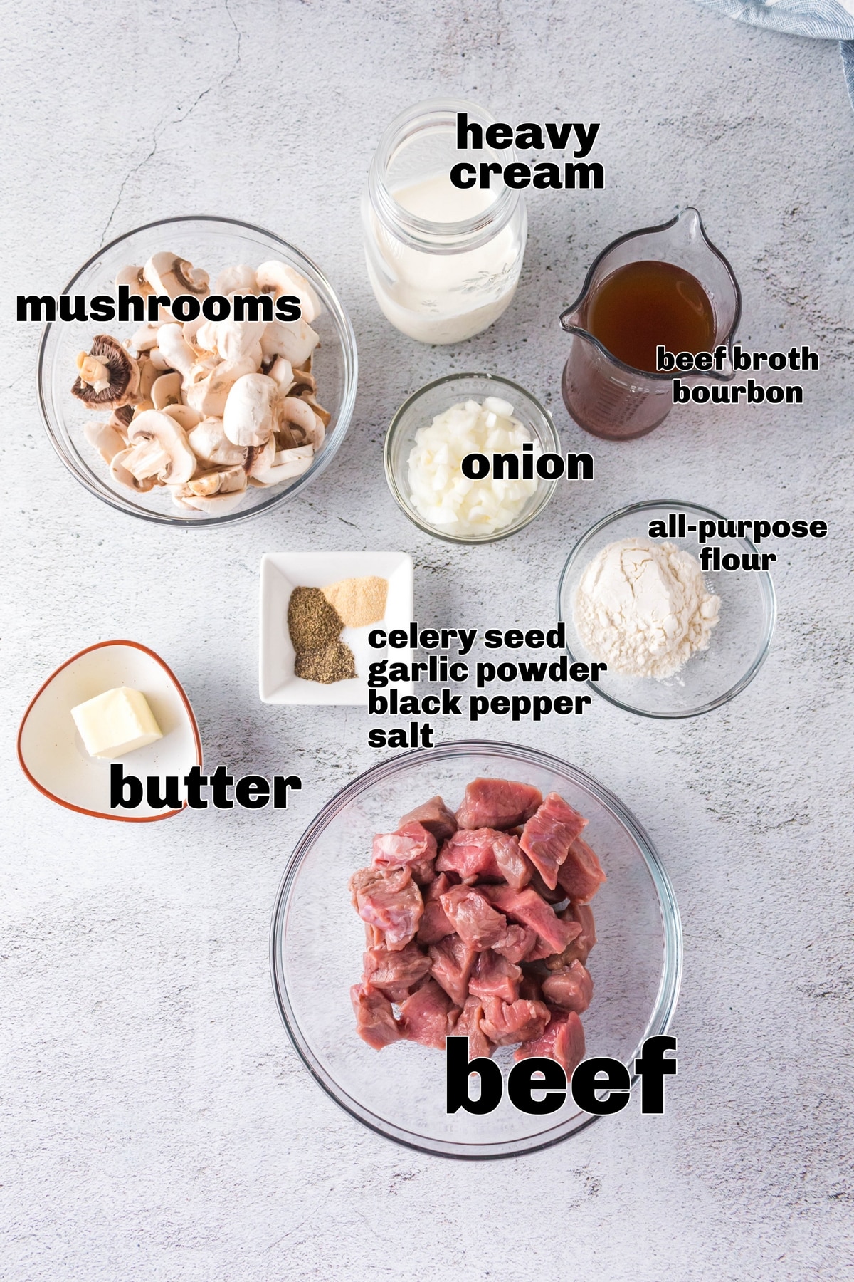 Stroganoff ingredients laid out for cooking Ingredients for beef stroganoff with heavy cream, bourbon, mushrooms, onions, and sliced beef