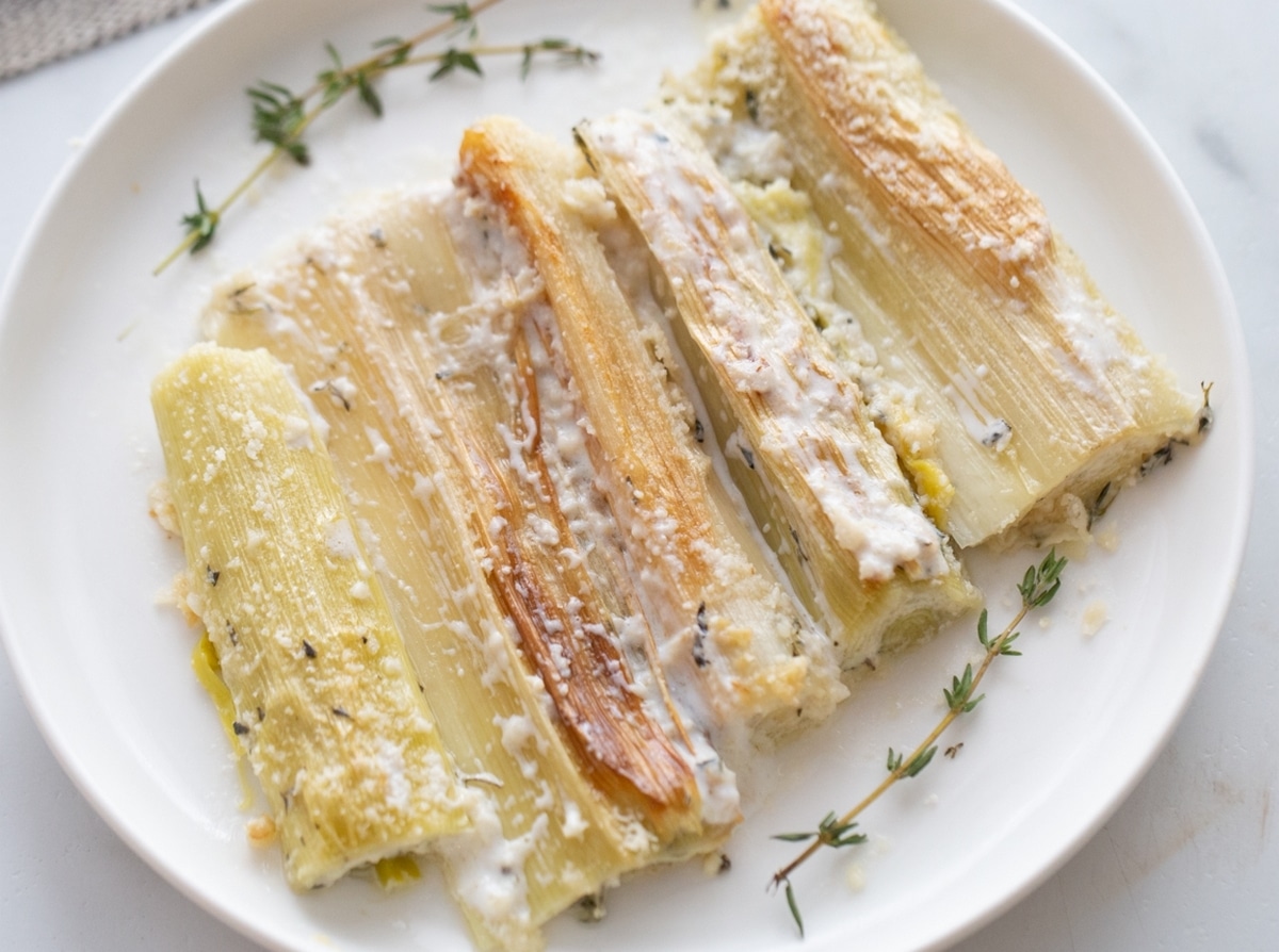 Creamy Roasted Leeks on a serving platter. roasted leeks in a creamy sauce