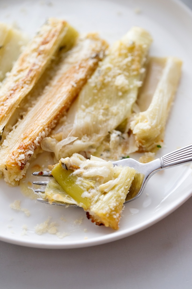 Creamy Roasted Leeks ready to eat. creamy roasted leeks on a white dish