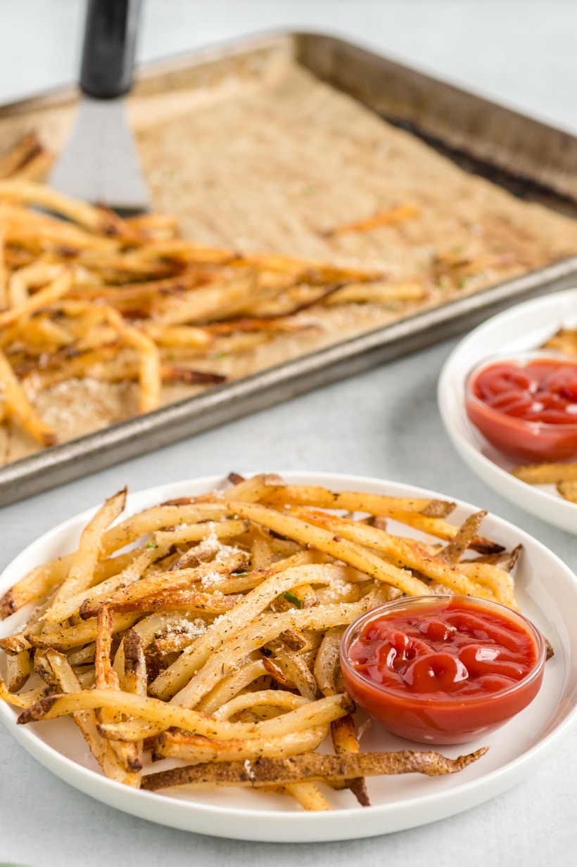 Baked French Fries (Oven Fries) on plates. Crispy Baked French Fries served with a side of ketchup for dipping.