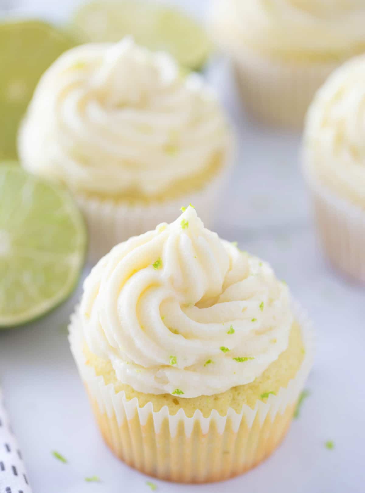 Close-up of a frosted key lime cupcake with lime zest on top