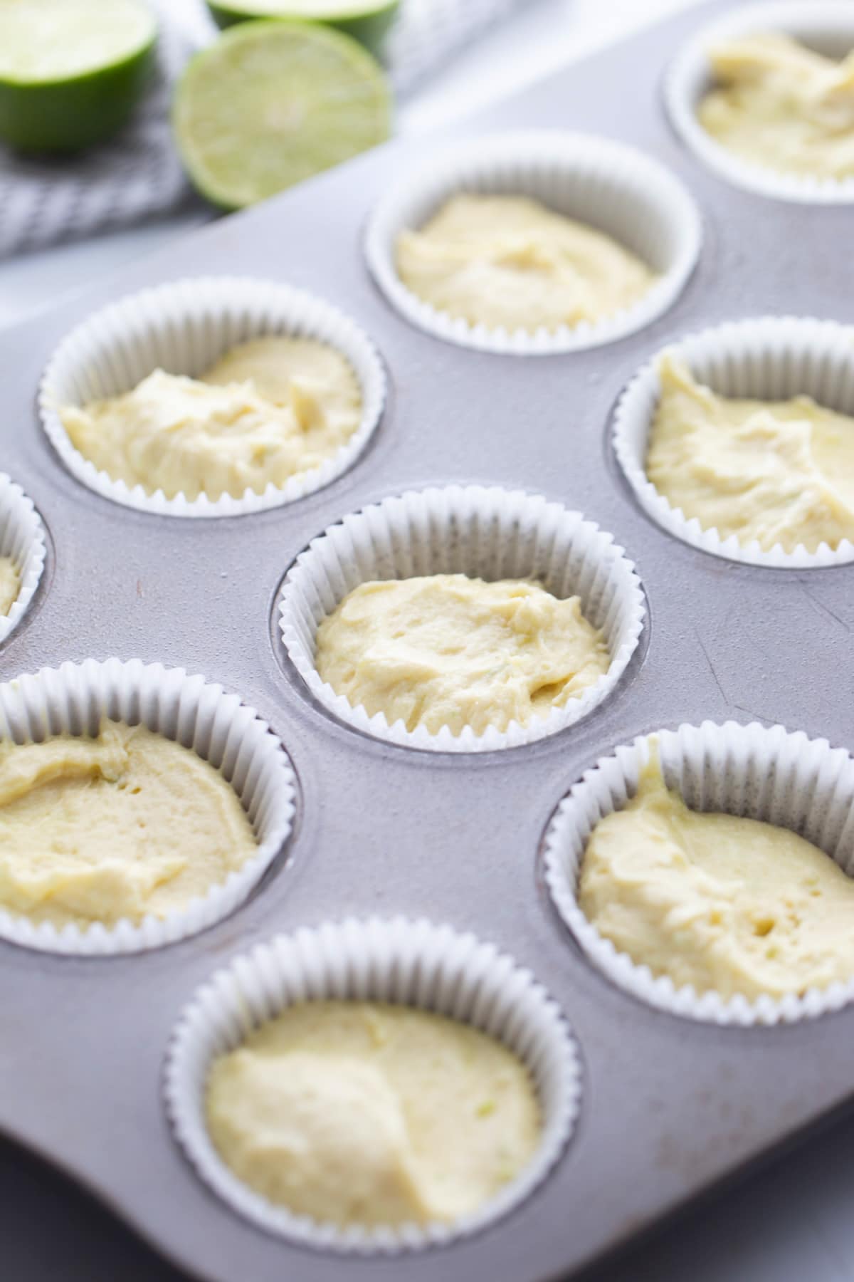 Cupcake pan filled with unbaked key lime cupcake batter