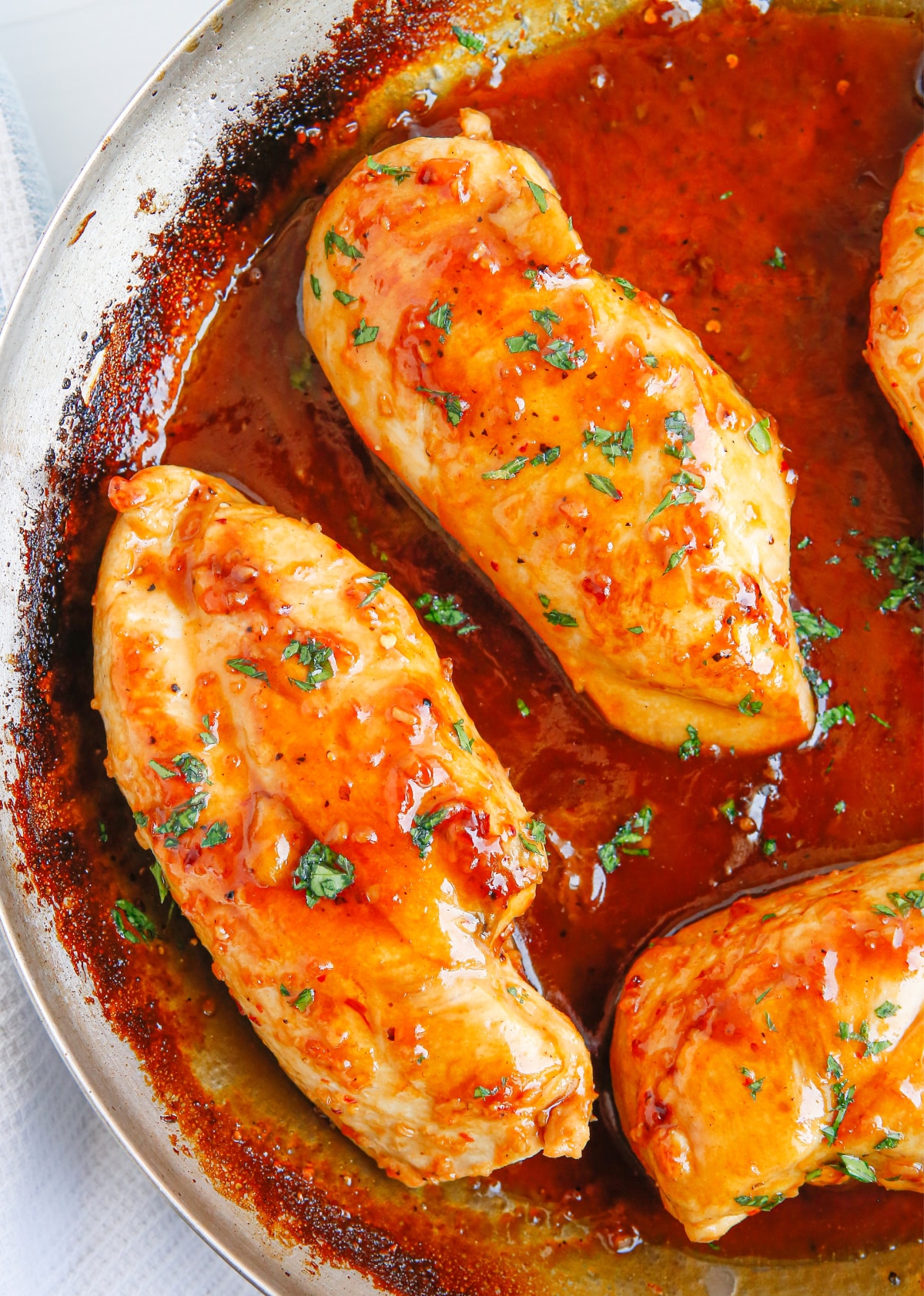 Finished Apricot Glazed Chicken Breasts Glazed apricot chicken breasts simmering in a skillet with a thick, glossy sauce.