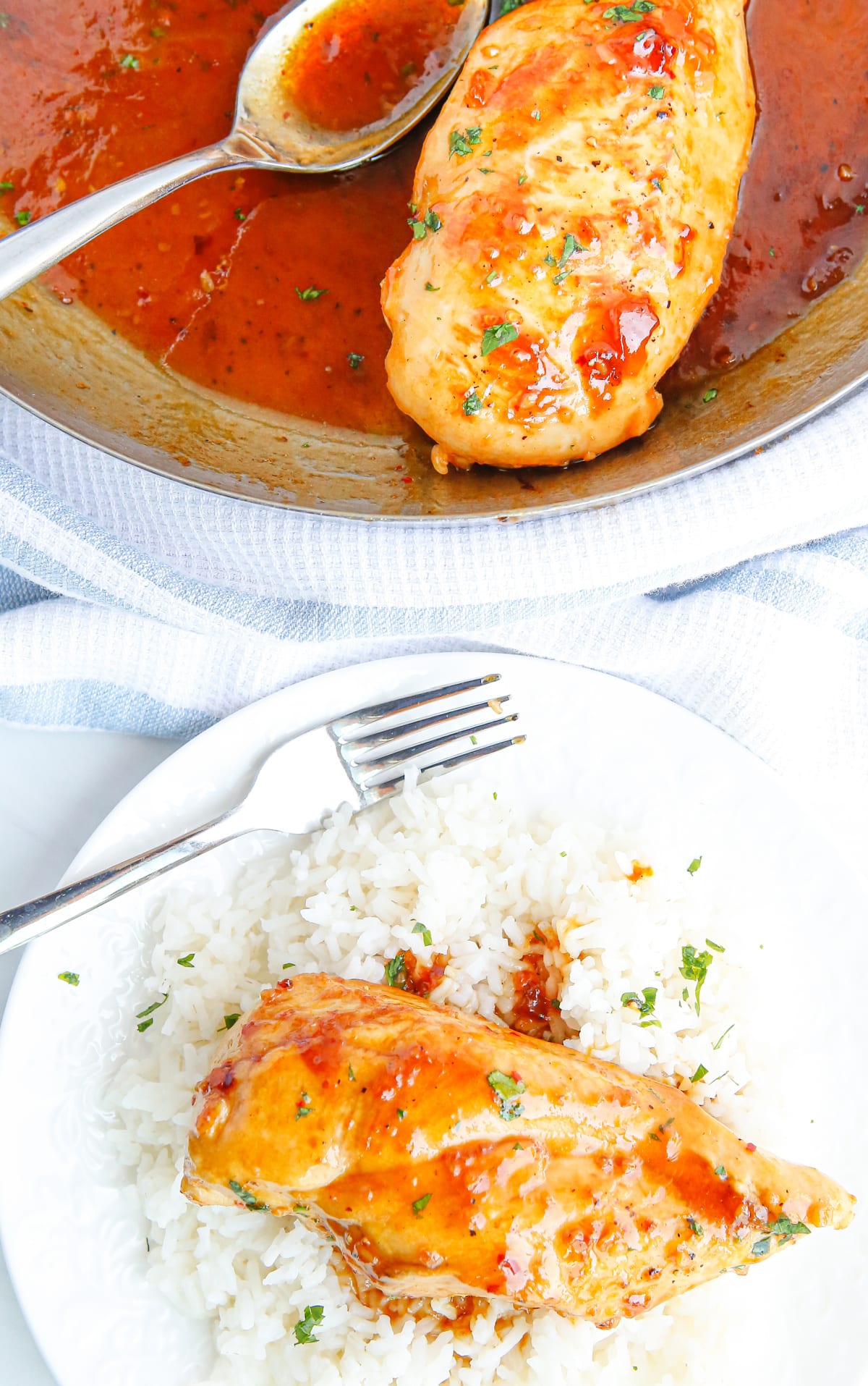 Apricot Glazed Chicken Breasts served over rice A plated chicken breast on a bed of rice, covered in apricot sauce, with the skillet of chicken in the background.