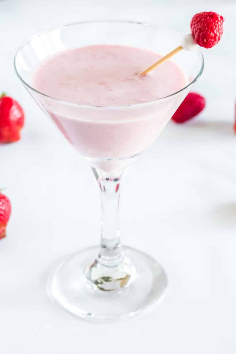Close-up of Berries and Cream Frozen Martini in a chilled martini glass, garnished with fresh raspberries.