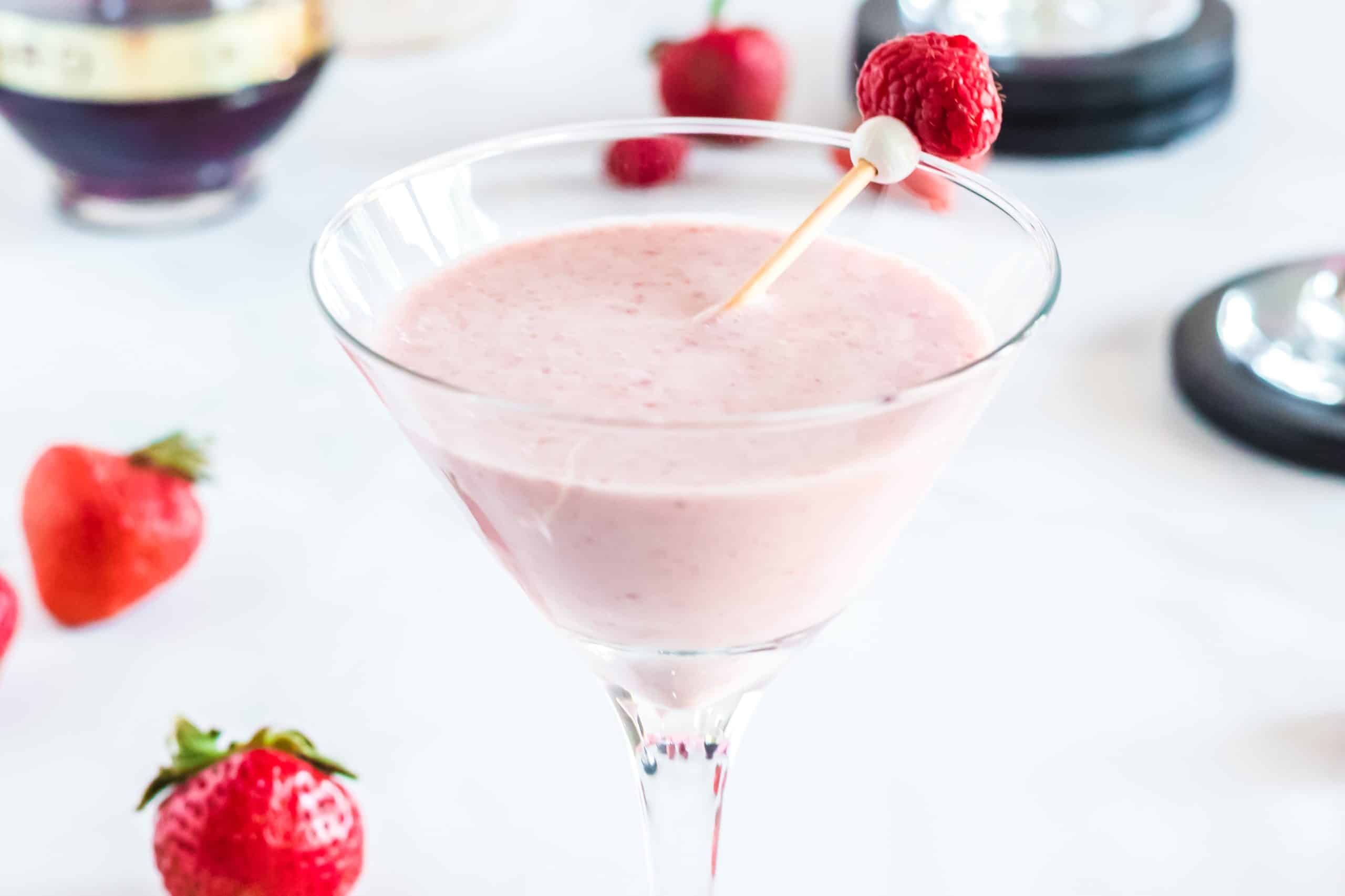 Side view of the berries and cream martini glass, highlighting the frosty, blended cocktail with condensation on the glass.