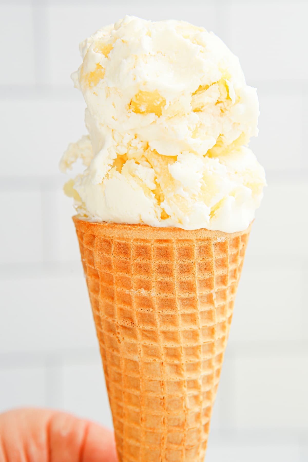 No-churn pineapple ice cream served in a cone Scoop of no-churn pineapple ice cream in a sugar cone