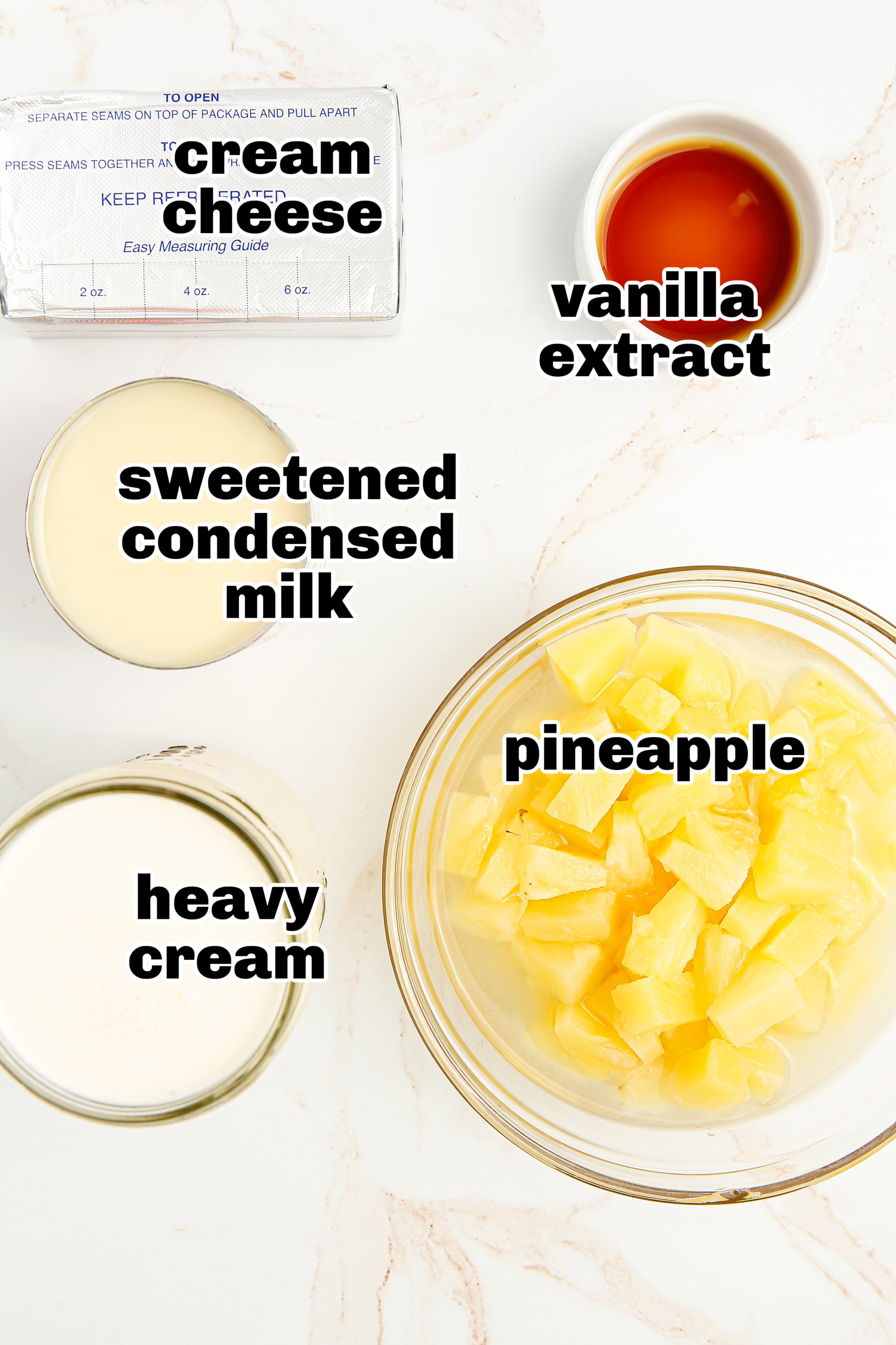 Cream cheese, pineapple, cream, and condensed milk for no-churn pineapple ice cream Ingredients for no-churn pineapple ice cream laid out on a counter