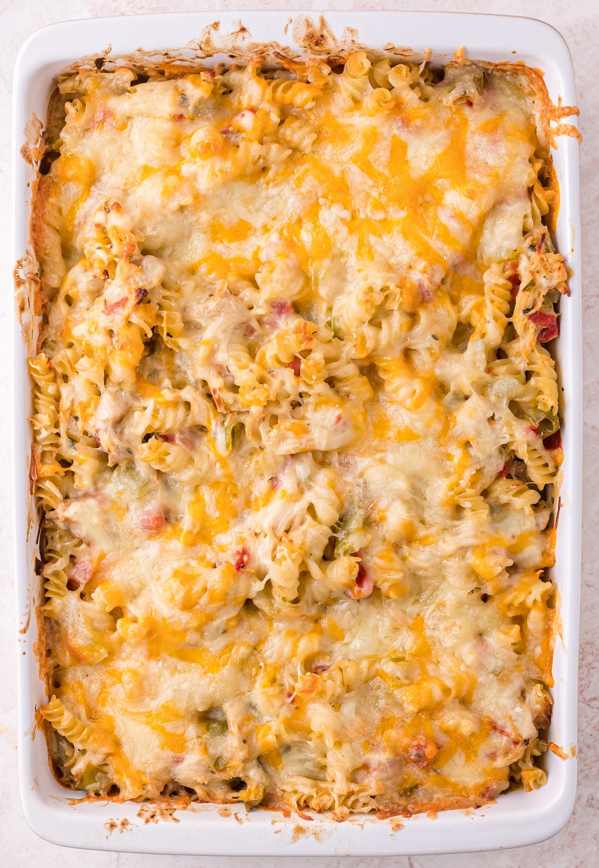 Baked Hatch green chile chicken casserole with melted cheese in a white 9x13 pan