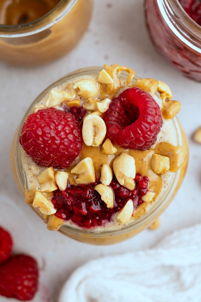 Peanut Butter and Jelly overnight Oats topped with raspberries. Peanut Butter and Jelly Overnight Oats with a drizzle of peanut butter and fresh raspberries.