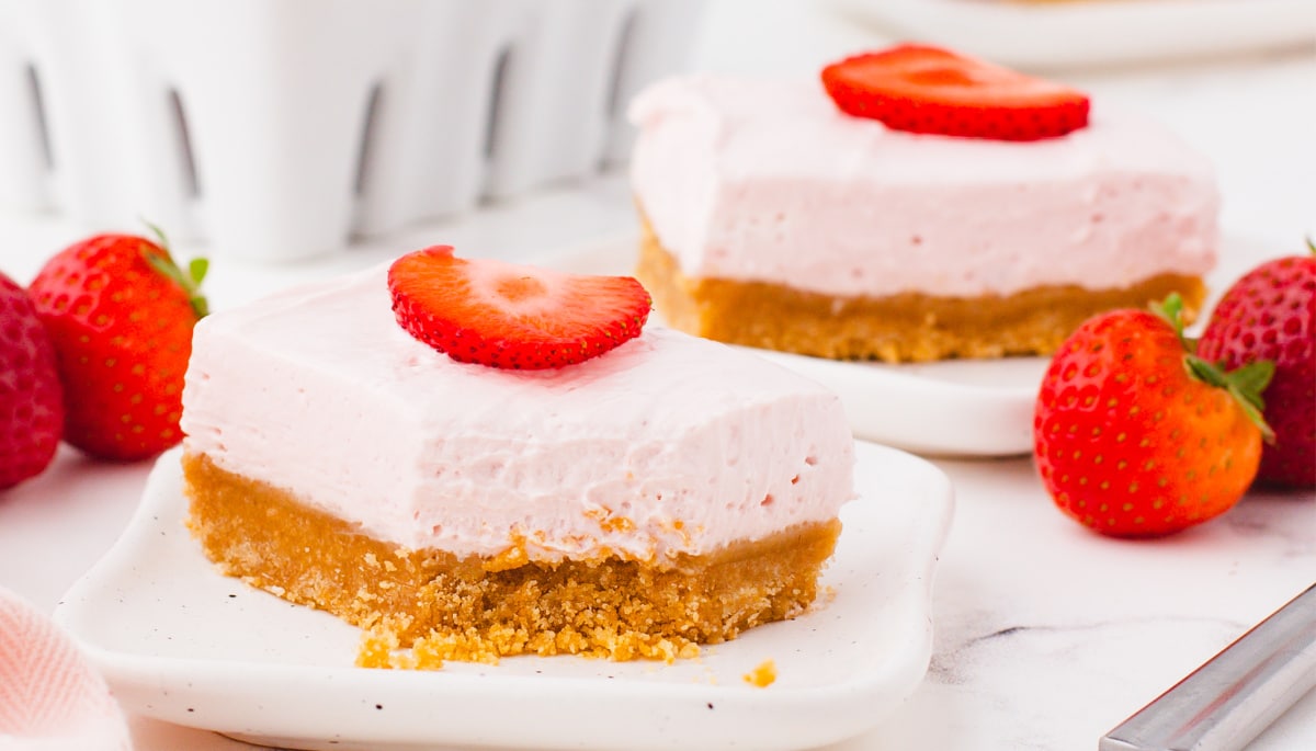 Side view of a strawberry cheesecake bar with a bite missing