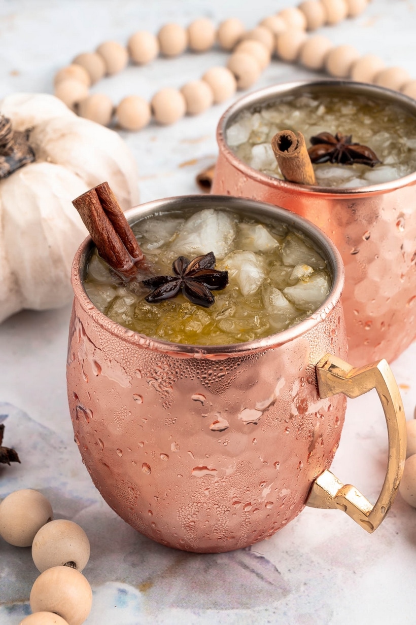 Pumpkin Spice Moscow Mules in Copper Mugs Side view of two Pumpkin Spice Moscow Mules served in copper mugs.