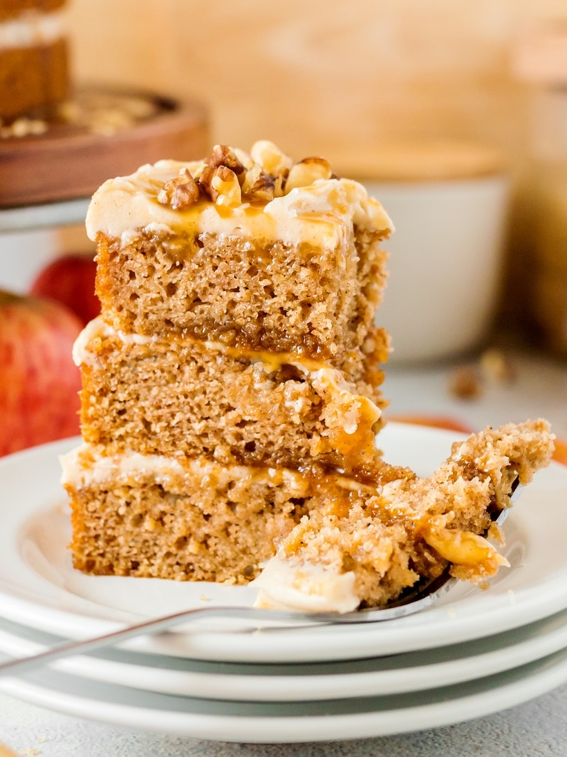 Close-Up of Caramel Apple Cake Slice Close-up of a layered slice of caramel apple cake with a fork taking a bite, emphasizing the texture and layers.