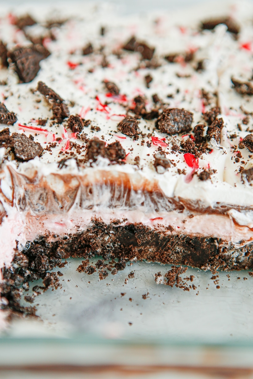 Make-Ahead Holiday Dessert with Crushed Candy Canes Close-up of chocolate peppermint lush with creamy layers and a candy cane garnish.