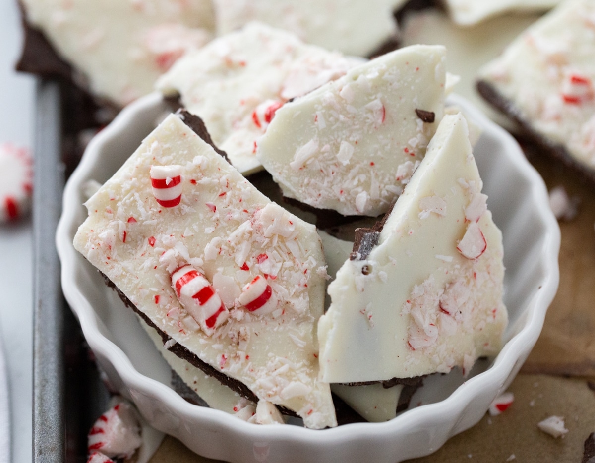 Peppermint Bark in a Bowl on a Baking Tray Double chocolate peppermint bark pieces in a white bowl, sitting on a baking tray.