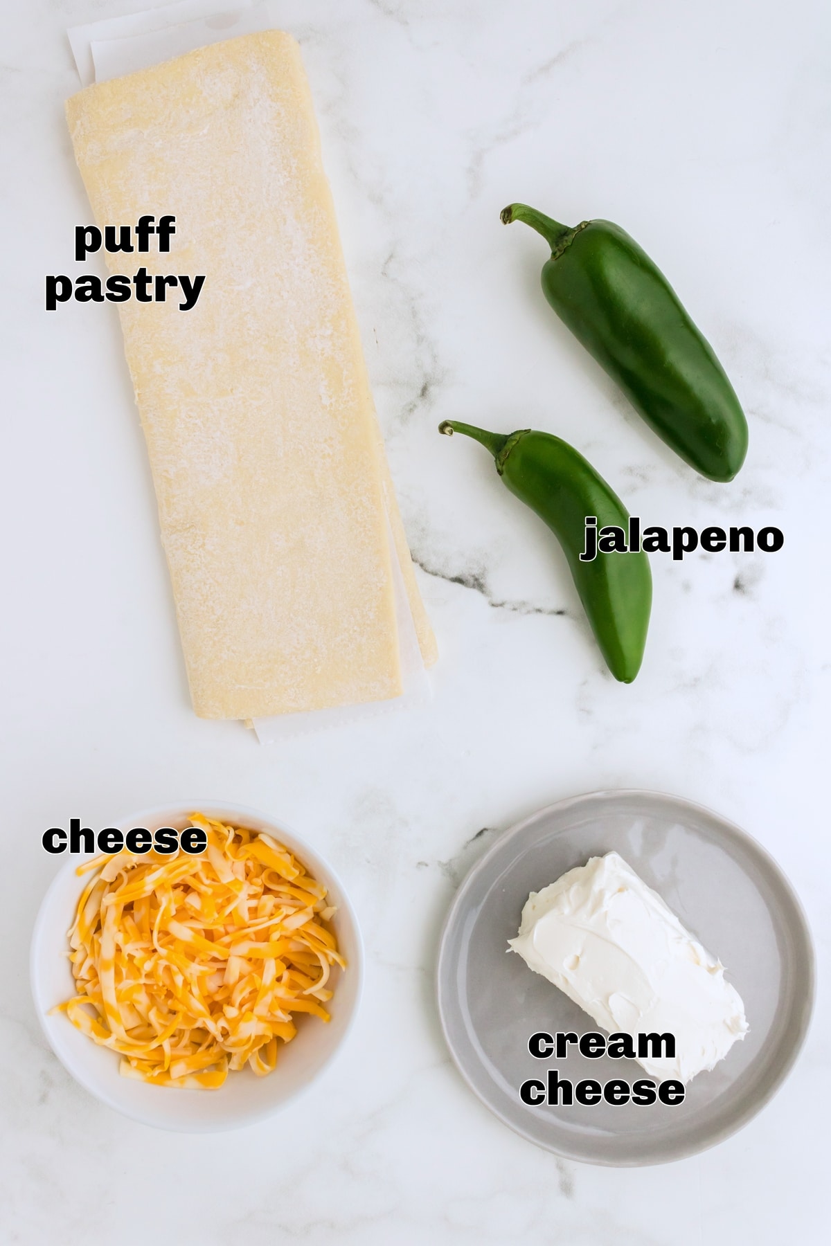 Jalapeno Popper Pinwheels ingredients A shot of the ingredients including cheeses and jalapeños, laid out on a countertop.