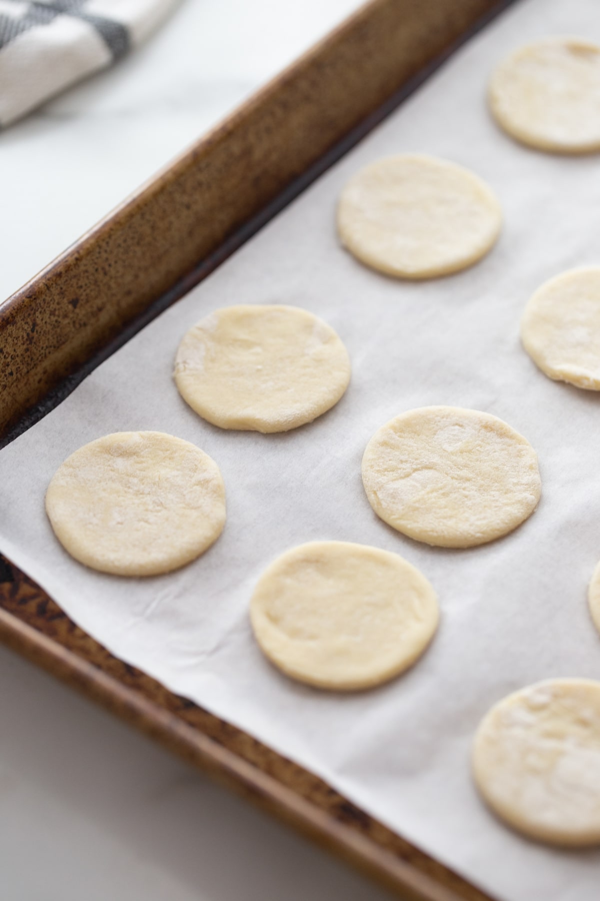 Puff Pastry Rounds Ready for Crab Filling Puff pastry rounds arranged on a parchment-lined baking sheet, ready for filling.