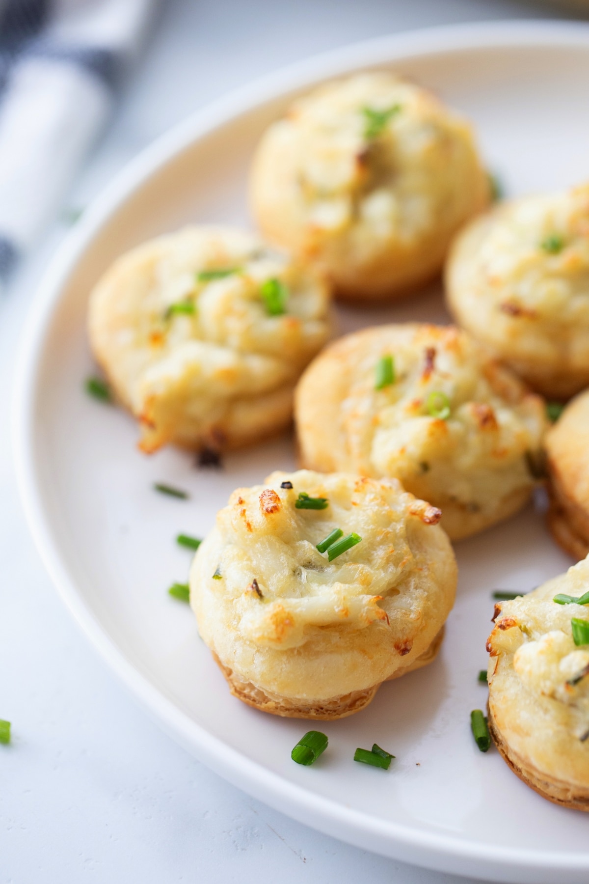 Crab and Chive Puffs Served on a White Plate A serving of crab and chive puffs arranged on a white plate, ready to enjoy.