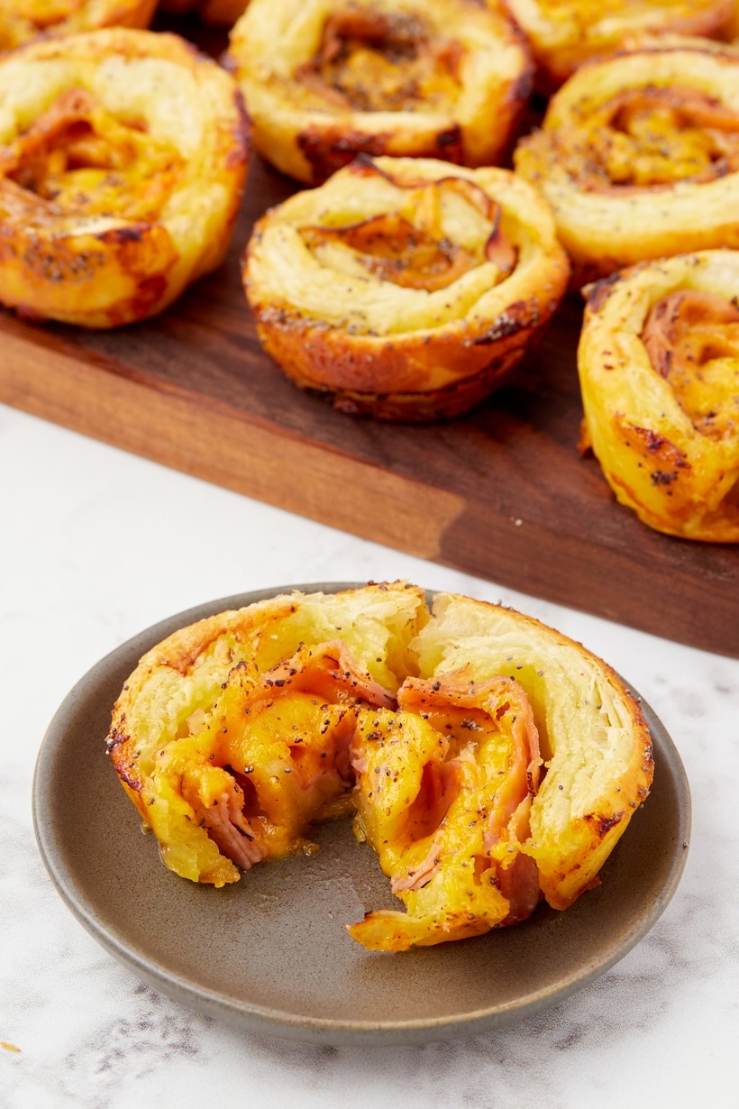 Ham and Cheese Pinwheels on a plate Ham and cheese pinwheels with a sweet and savory glaze brushed on top.