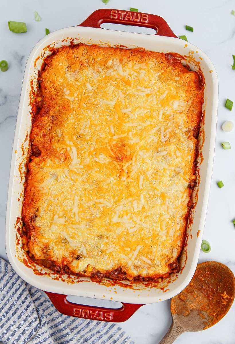 Freshly baked tamale pie in a casserole dish, with a golden brown cornbread topping and bubbling edges.