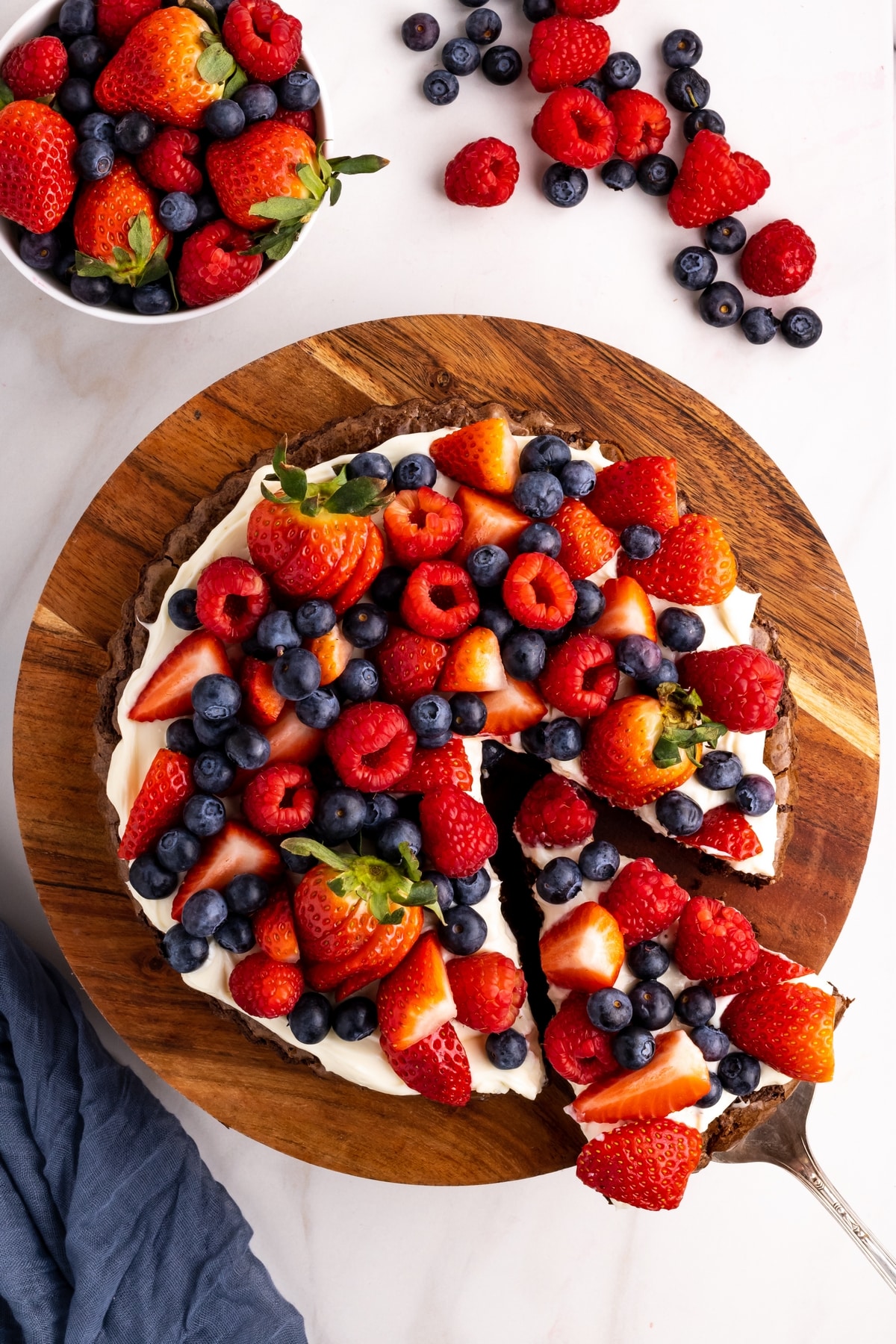 Brownie pizza dessert topped with strawberries, blueberries, and raspberries