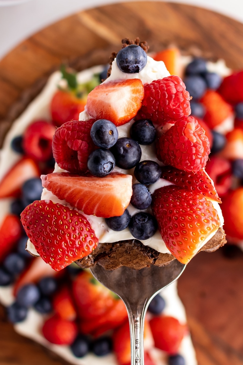 Slice of brownie dessert pizza with fresh fruit and frosting