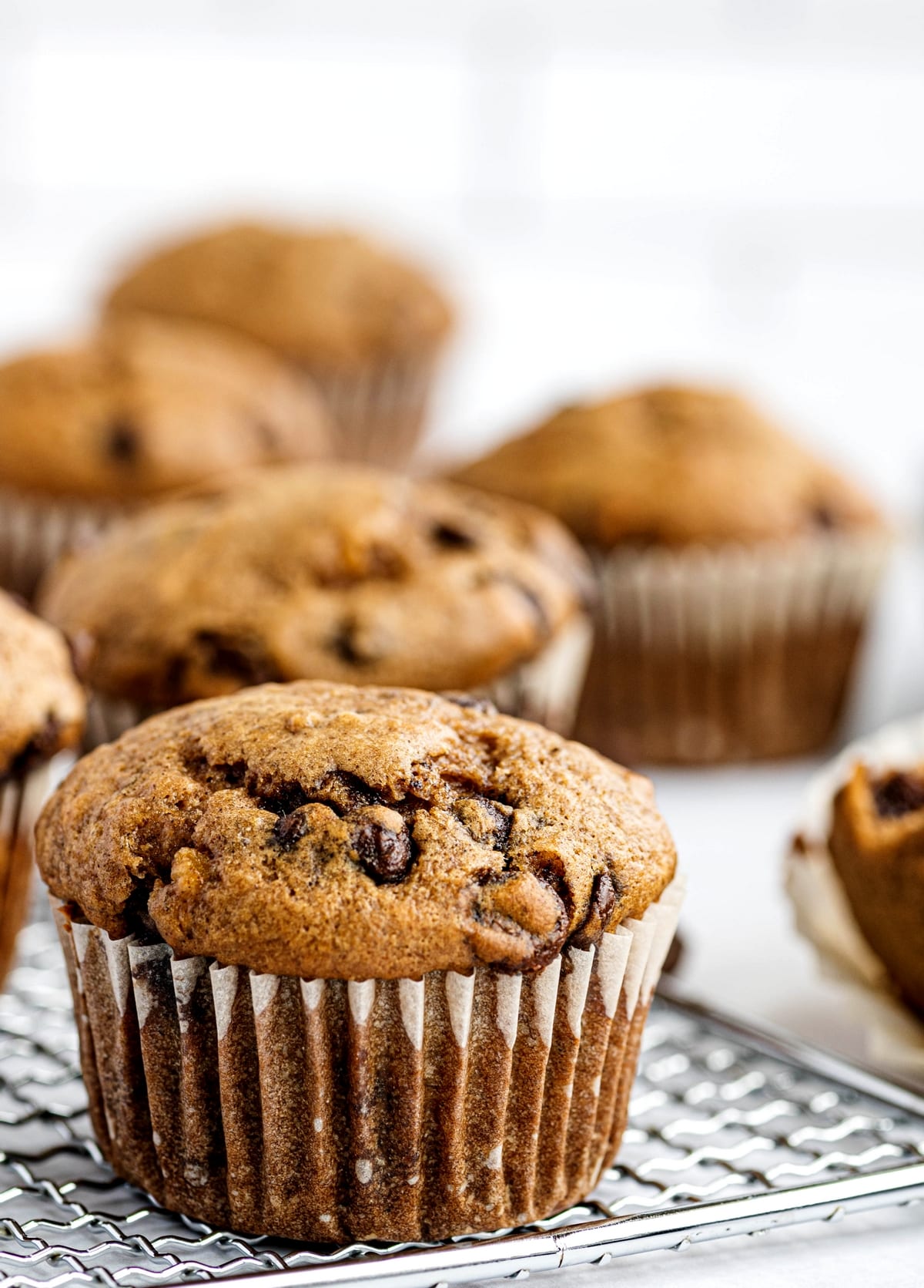 Chocolate Chip Banana Muffins in paper liners chocolate chip banana muffins on a cooling rack
