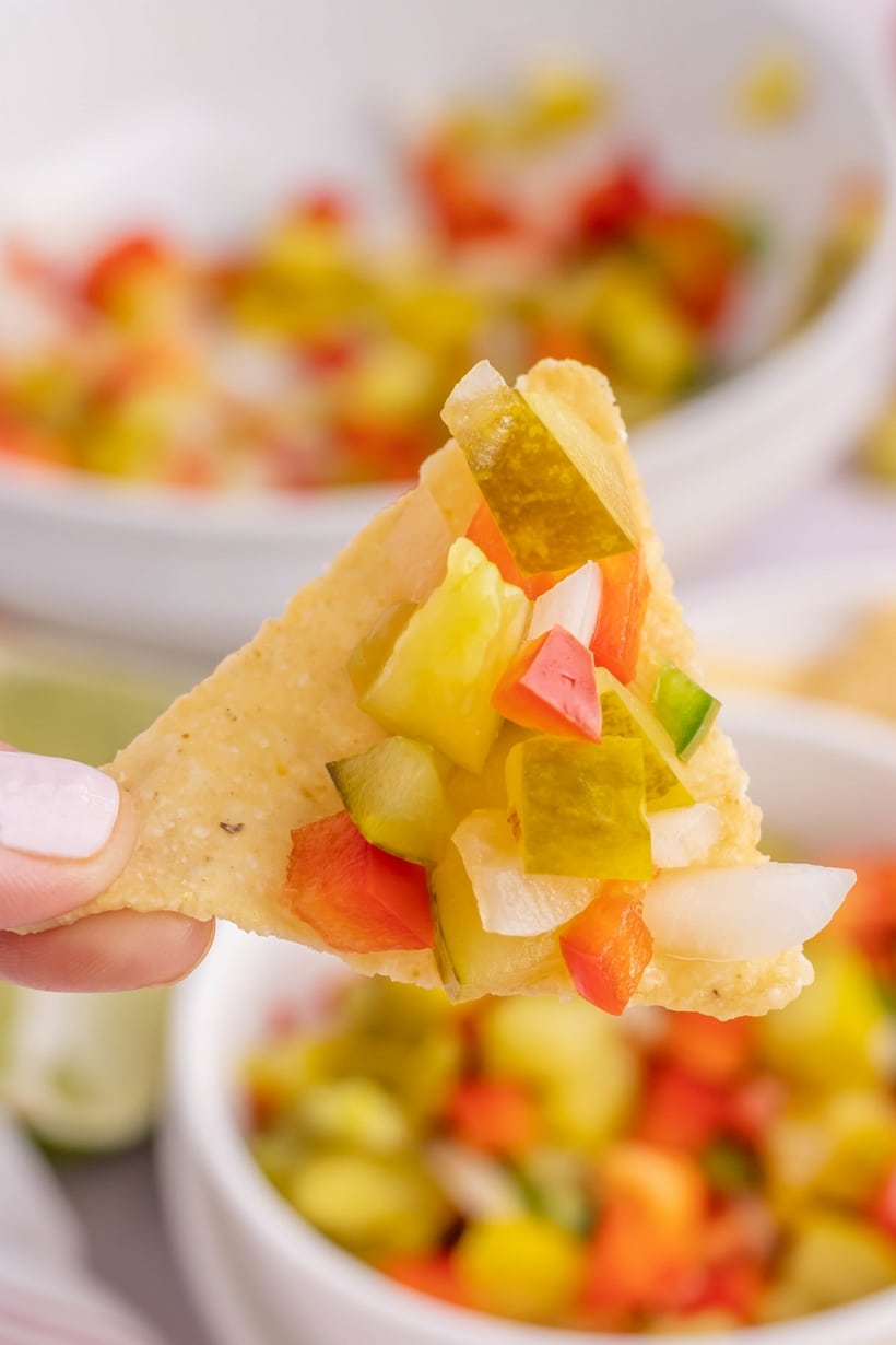 Pickle de Gallo - a tangy twist on the classic, this dill pickle salsa packs a puckering punch. This briny, garlicky, dip is great for dunking tortilla chips or used as a spread on burgers or sandwiches. dill pickle salsa with chips