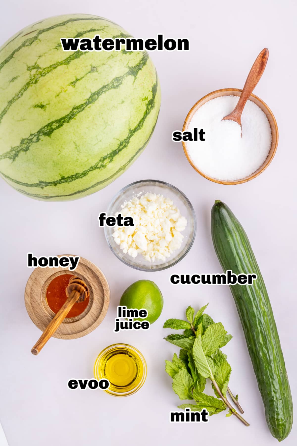Ingredients for watermelon mint salad with cucumber, feta, and dressing Overhead view of prepped ingredients for watermelon feta mint salad