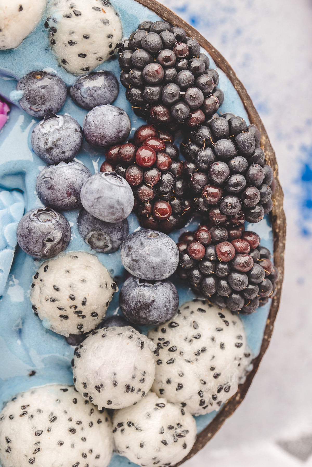 Dragon fruit, blueberries, and blackberries complete the underwater look. Close-up of dragon fruit, blueberries, and blackberries on top of a blue smoothie bowl.