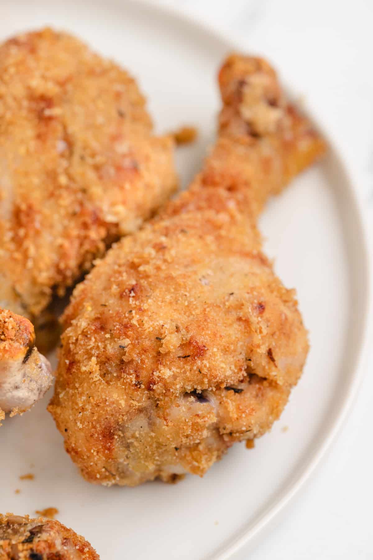 Golden Panko Chicken Drumstick golden panko crusted chicken drumstick close up on a white plate