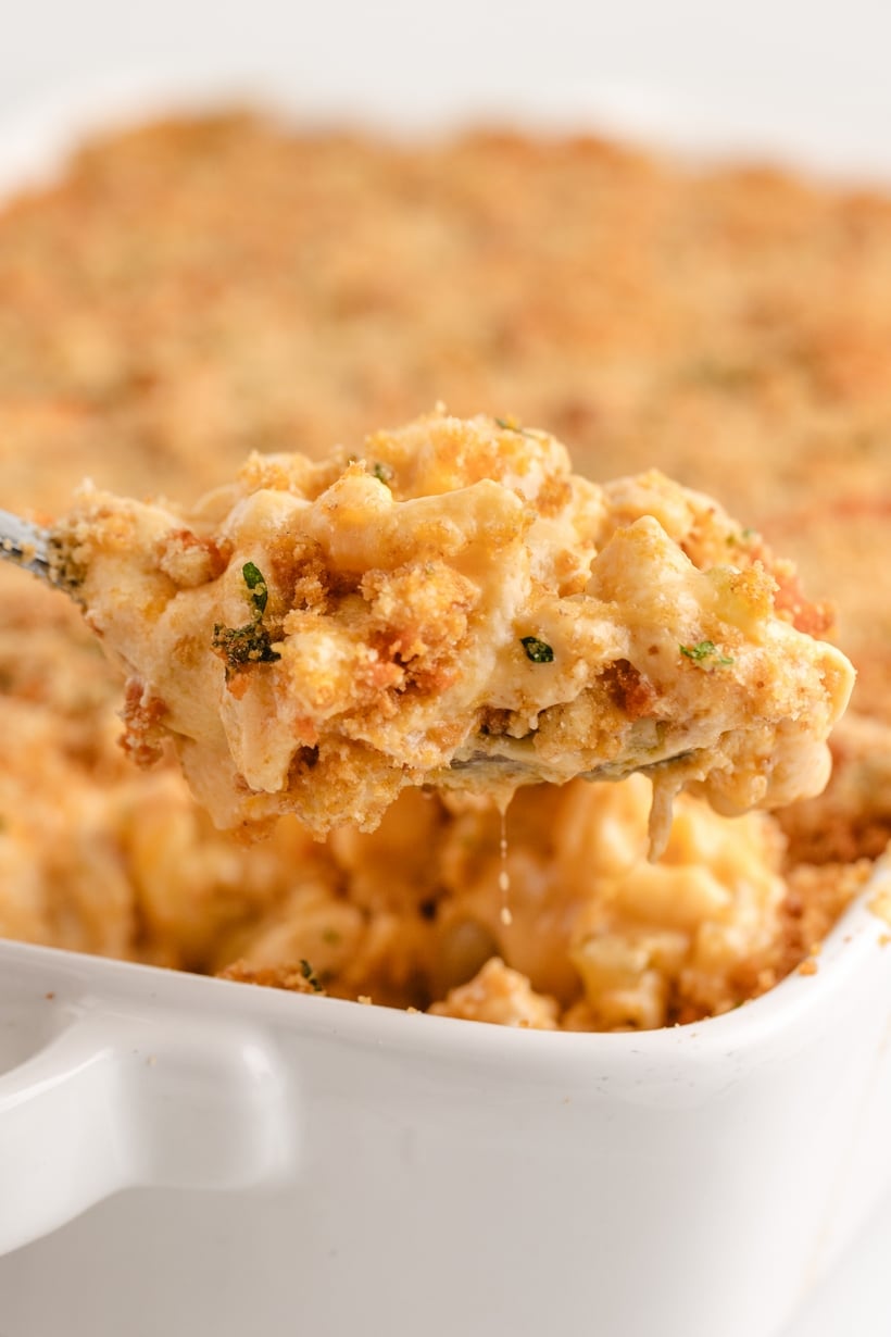 Taking a scoop out of buffalo chicken macaroni and cheese baking dish.