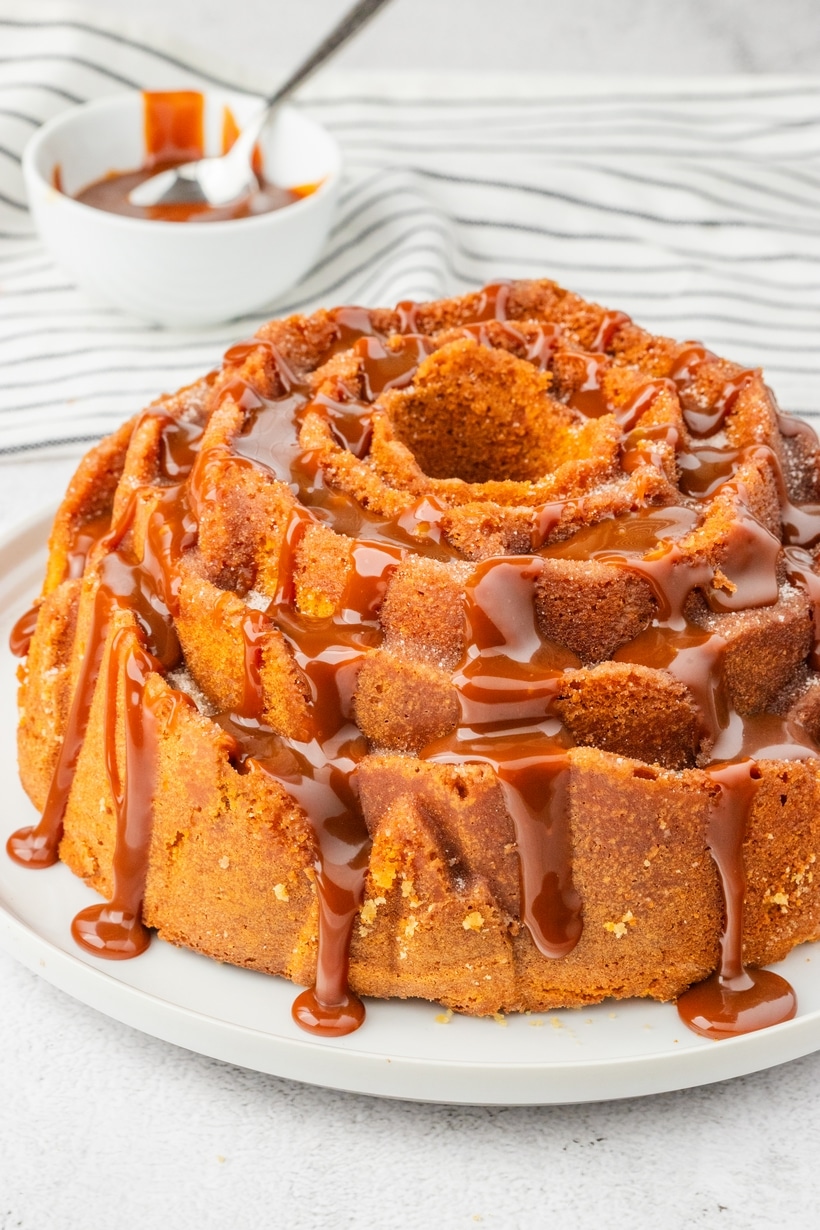 churro bundt cake with dulce de leche drizzle on a white plate