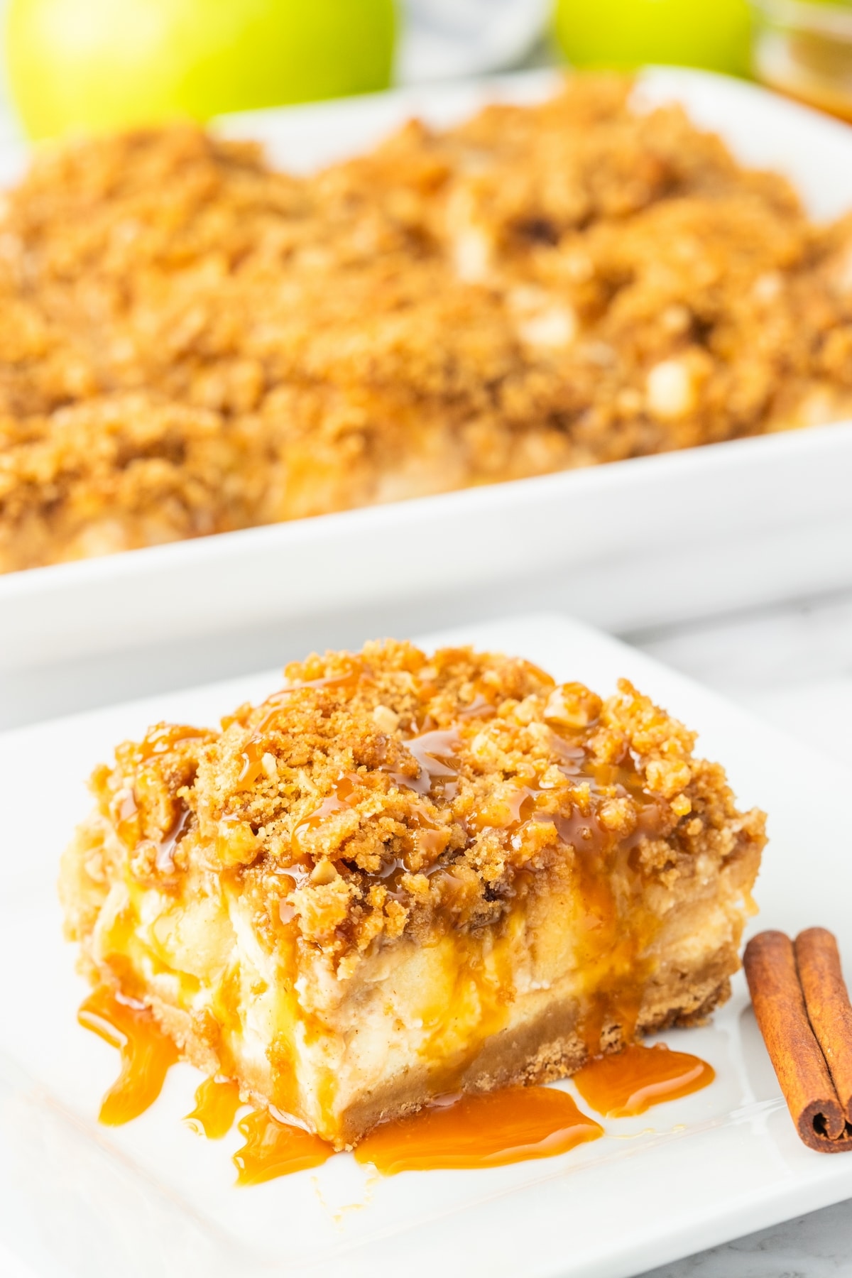 Caramel apple cheesecake bar slice. Slice of caramel apple cheesecake bar on a plate with shortbread crust and streusel topping.