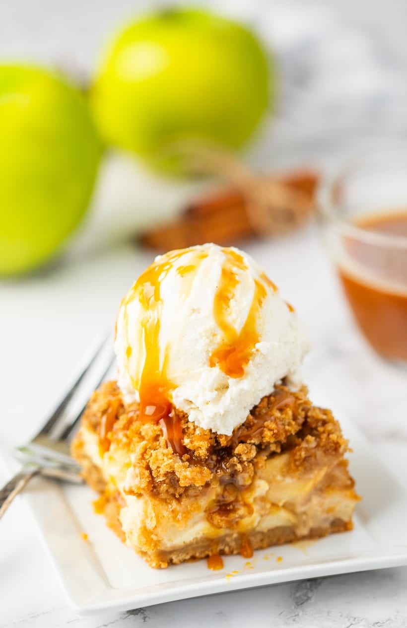 Apple crisp cheesecake bar with ice cream. Apple crisp cheesecake bar topped with vanilla ice cream and caramel.