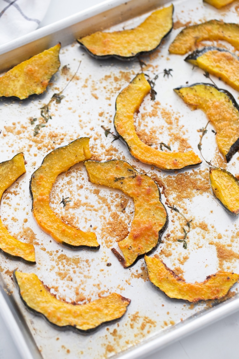 baked acorn squash with Parmesan and thyme on a sheet pan after roasting