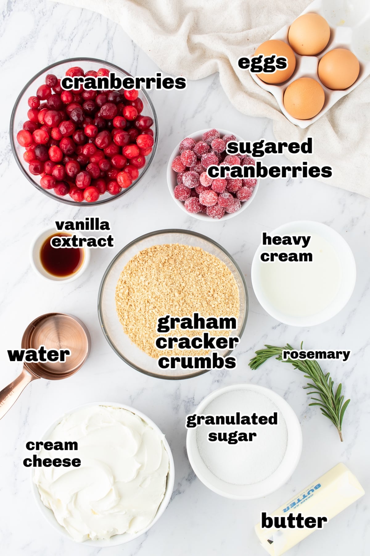 Ingredients for Cranberry Cheesecake Recipe. Ingredients for cranberry cheesecake arranged on a countertop, including cream cheese, cranberries, sugar, and graham crackers.