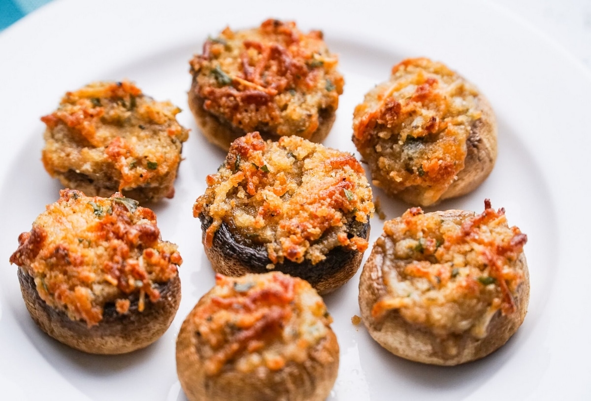 Close-up of Italian stuffed mushroom with savory filling. Close-up of a single Italian stuffed mushroom on a plate.