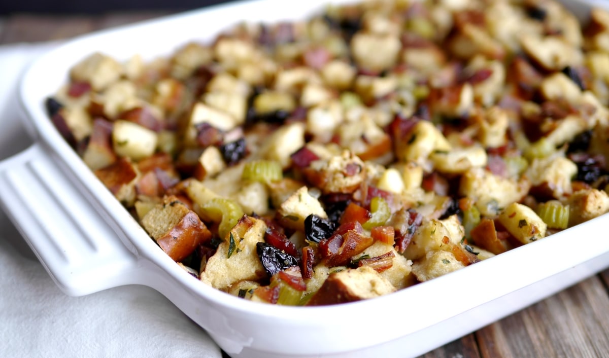 Close-up of pretzel bread stuffing with crispy top in a white baking dish.