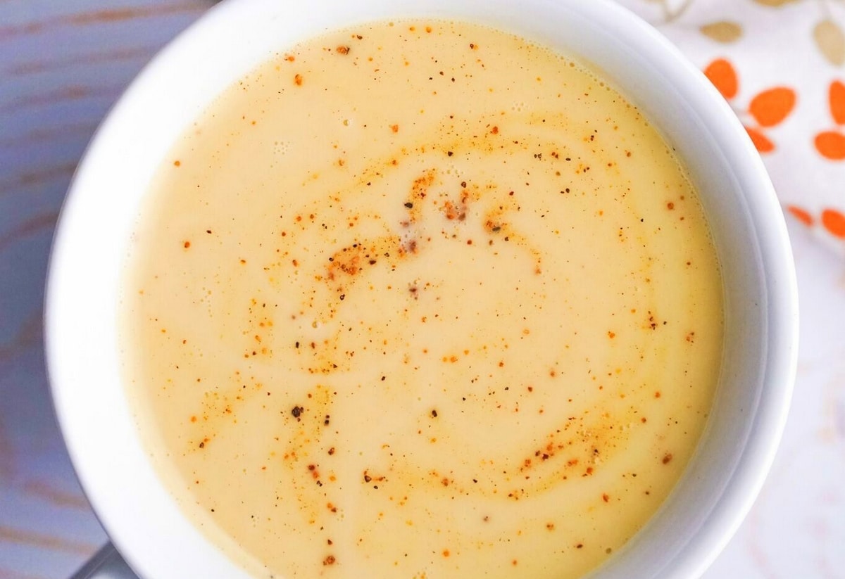 Close-up of creamy Chai Eggnog in a mug with nutmeg garnish.