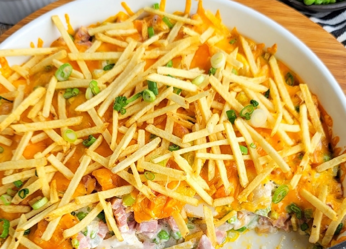Ham and Cheese Casserole with Crunchy Topping half-eaten Overhead view of the casserole with half removed, showing the creamy filling and cheesy topping.
