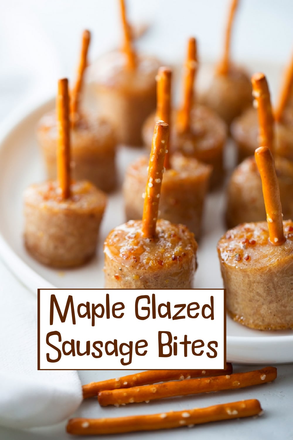 Enjoy these maple-glazed sausage bites—tender pieces perfectly coated in a rich, sweet sauce. Skewered with pretzel sticks for easy grabbing, they're ideal for any casual gathering or holiday party. via @cmpollak1