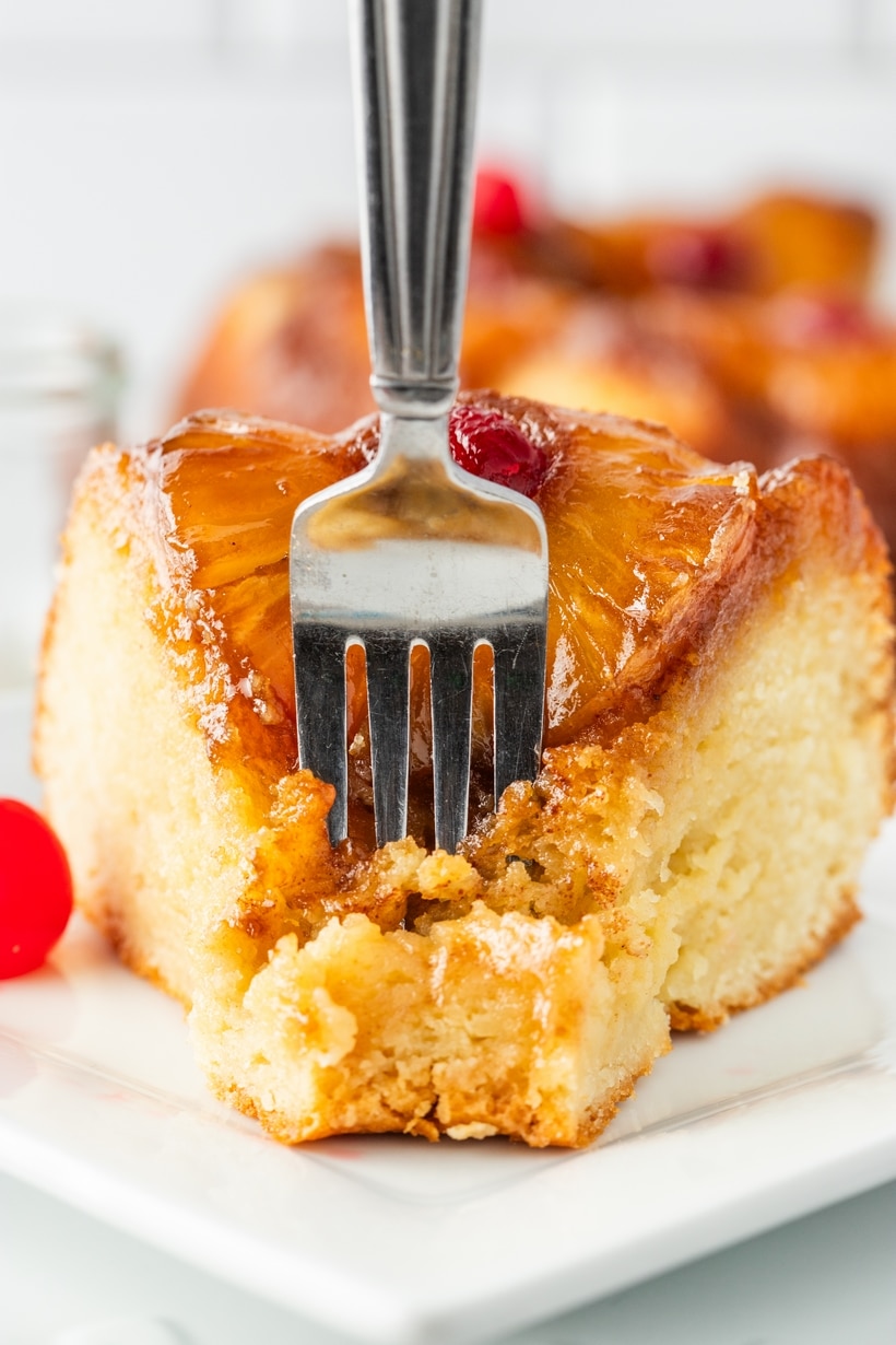 Pineapple Upside Down Cake Slice with Fork Close-up of a slice of pineapple upside down Bundt cake with a fork pressed into the tender Greek yogurt crumb and caramelized topping.