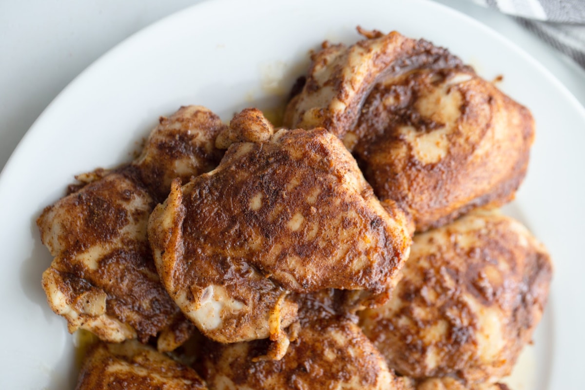 Top view of whole pieces of Air Fryer Caribbean Spiced Chicken on a white platter.