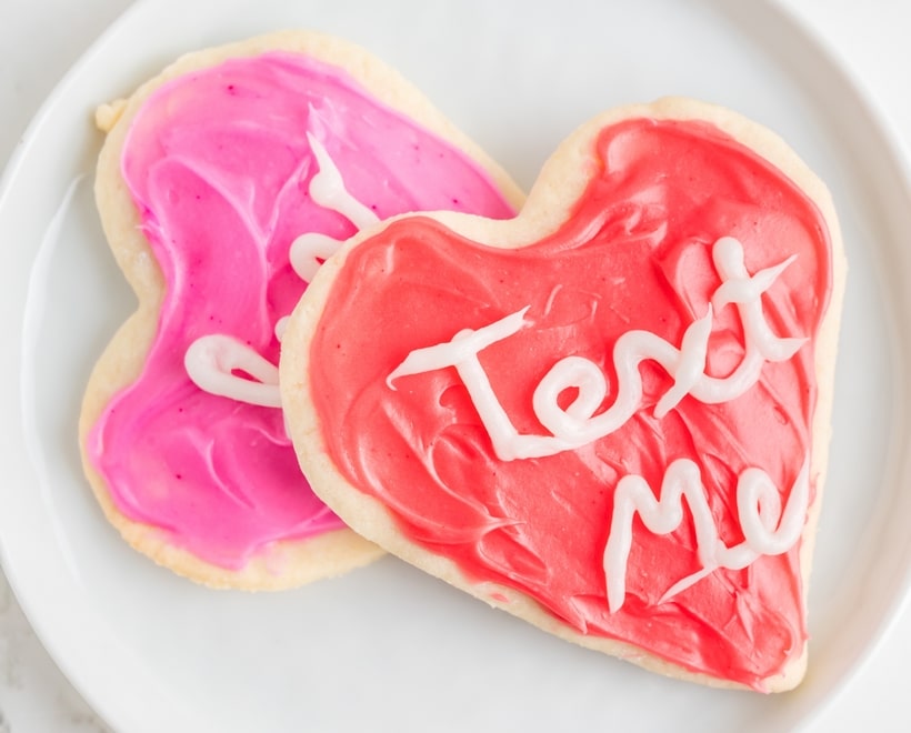 Two decorated Heart-Shaped Sugar Cookies A stack of decorated heart-shaped cookies on a plate, showcasing their soft texture and colorful frosting.