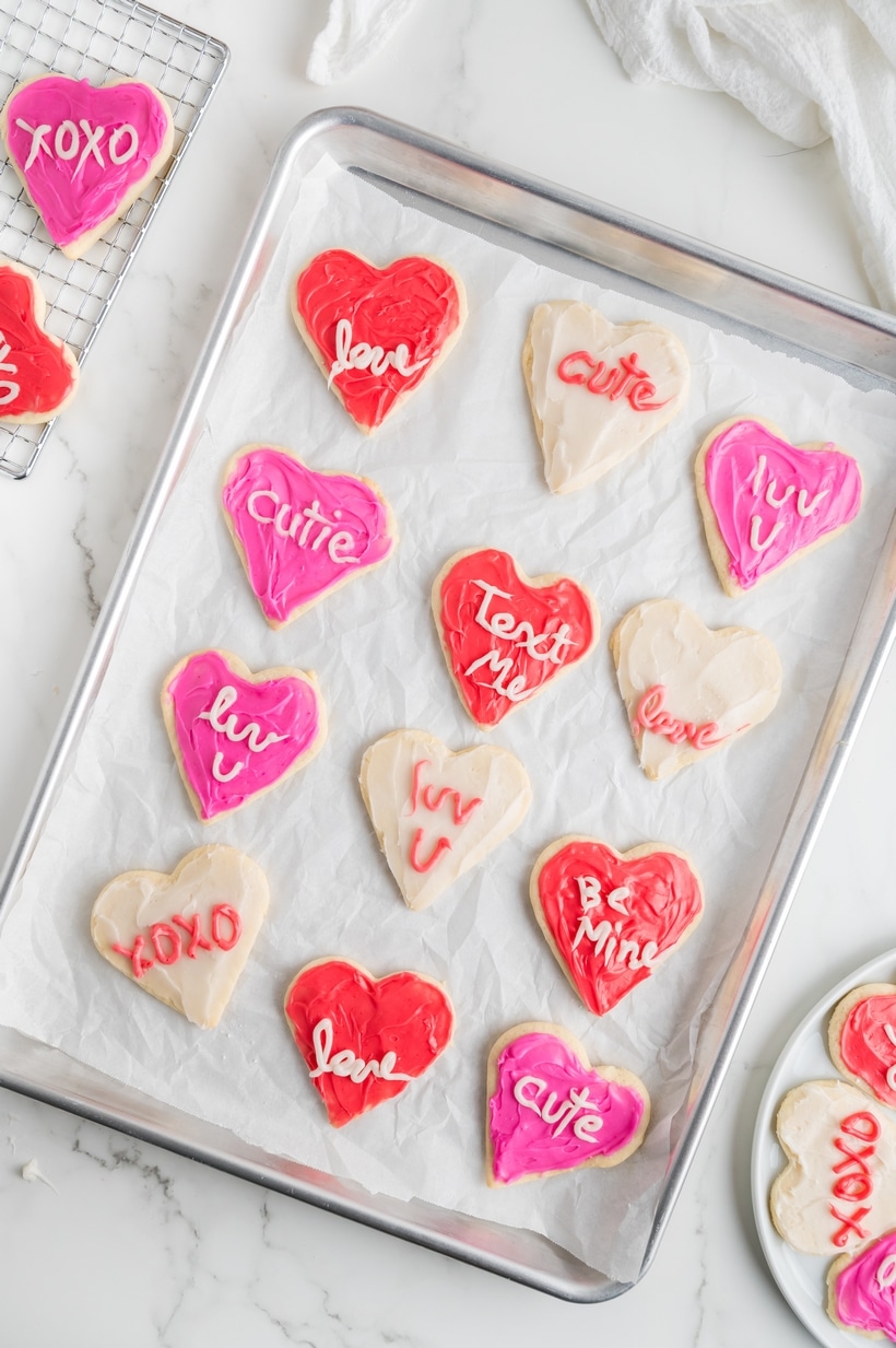 Heart-Shaped Sugar Cookies on a baking tray A baking sheet lined with freshly baked heart cookies before decorating, showing their smooth and even shape.