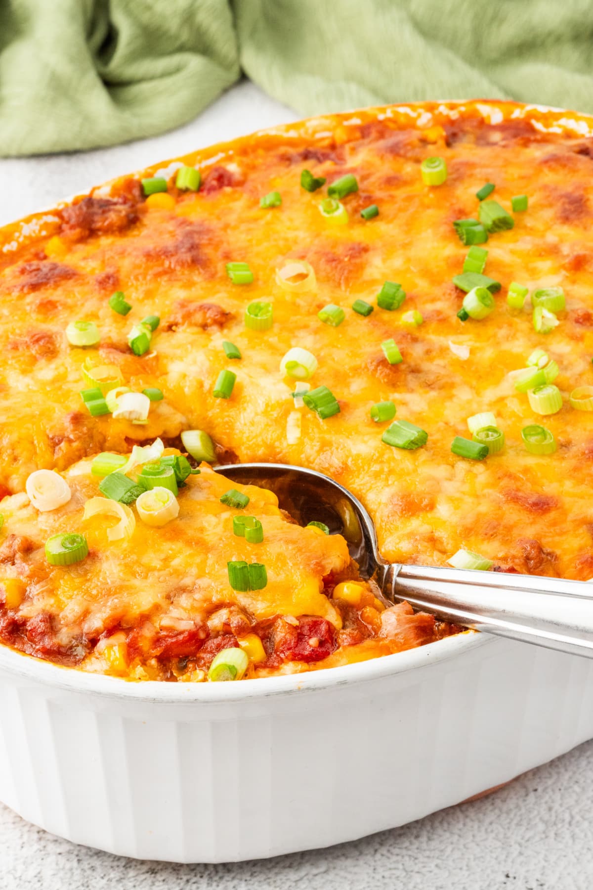 Hot and bubbling ground beef pasta casserole with cheese and green onions