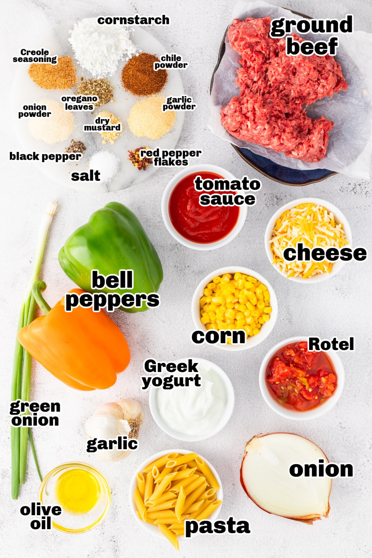 Ingredients for ground beef casserole with pasta, including peppers, beef, cheese, and seasonings
