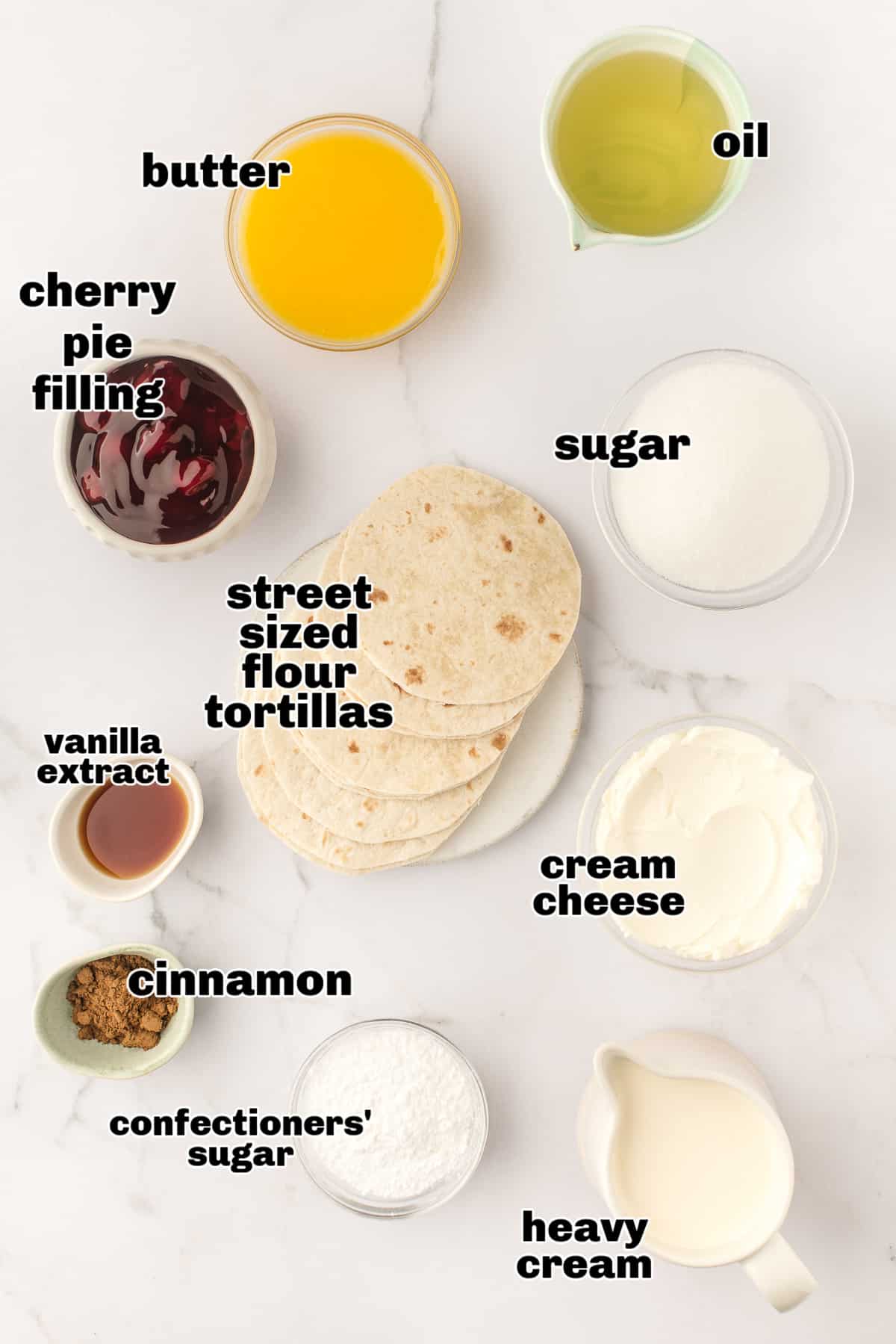 Ingredients for cherry cheesecake tacos including tortillas, cream cheese, heavy cream, cherry pie filling, and cinnamon sugar.